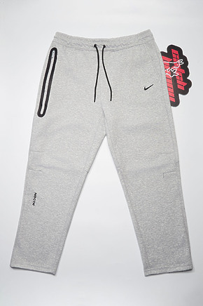 Серые спортивные штаны Nike Nocta в наличии