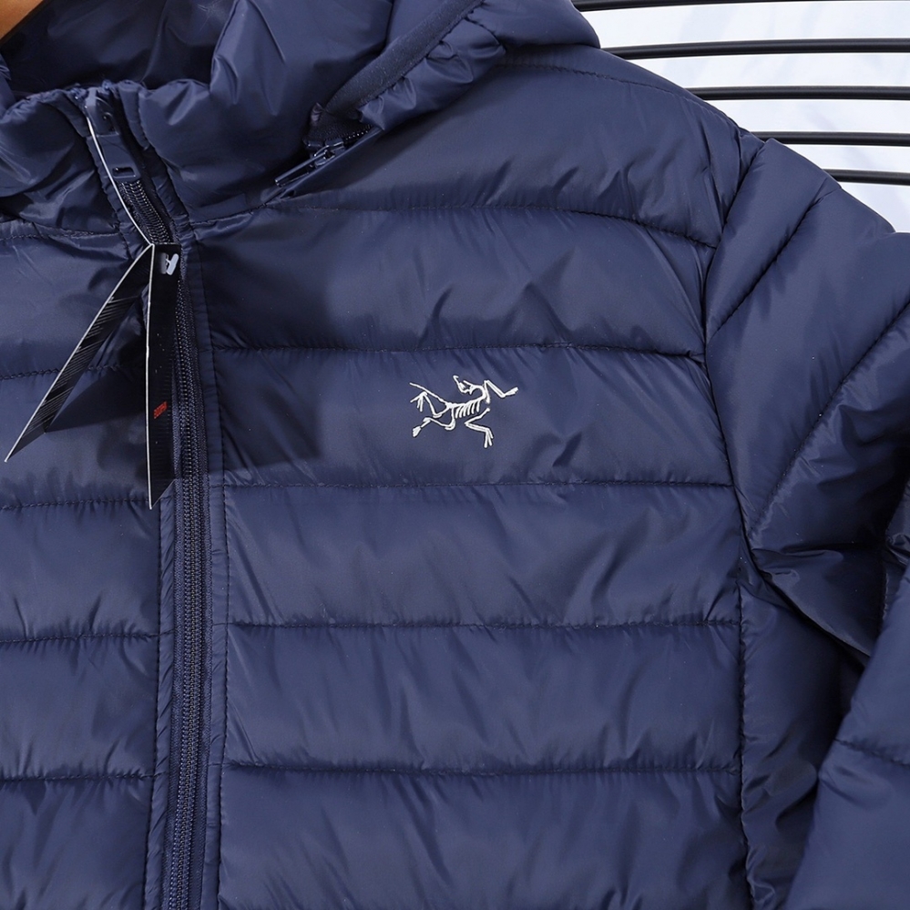 Синяя болоньевая куртка Arcteryx с капюшоном и фирменным логотипом