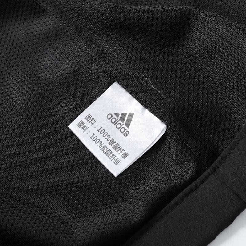 Чёрная куртка Adidas выполнена из 100% полиэстера со съёмным капюшоном