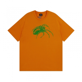 Принт зеленного паука на оранжевой футболке Stussy 