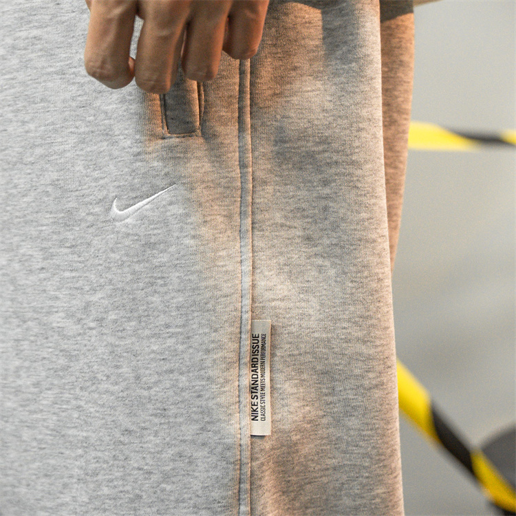 Теплые джоггеры Nike выполнены в светло-сером цвете
