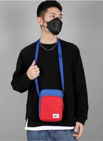 Плечевая красная сумка с синим ремешком Nike выполнена из полиэстера