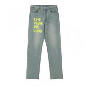 Голубые джинсы от бренда VLONE с желтой надписью спереди