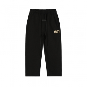 Черные штаны бренда essentials с удобными карманами и нашивкой "1977"