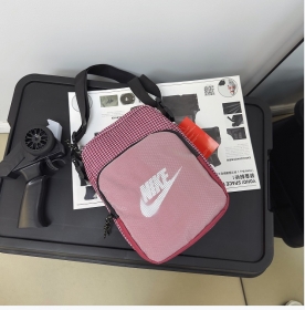 Малиновая сумка выполнена из плотного текстиля в клетку с лого Nike 
