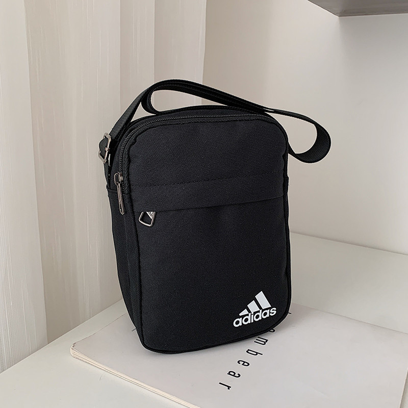 Чёрного цвета сумка-барсетка фирмы Adidas на регулируемом ремне