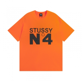 Футболка оранжевого цвета STUSSY с большим черным лого и принтом "№4"