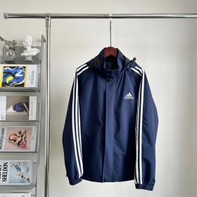 Темно-синего цвета ветровка с капюшоном от бренда Adidas