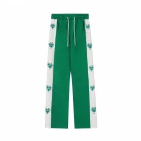 Зеленые с брендовыми принтами на белых лампасах штаны от SEVERS