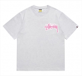 В сером цвете футболка BAPE с розовой надписью на груди